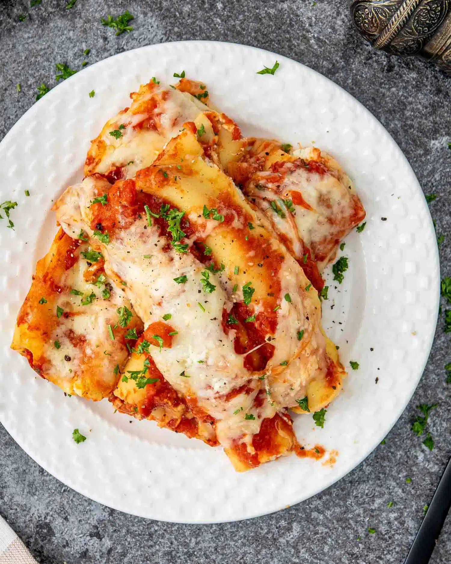 a serving of cheese stuffed manicotti on a white plate.