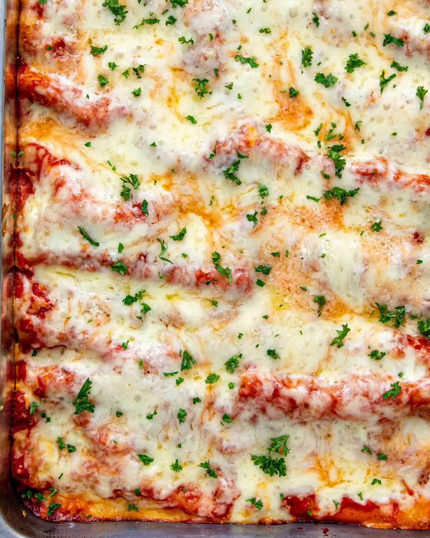 freshly made cheese stuffed manicotti in a casserole dish.