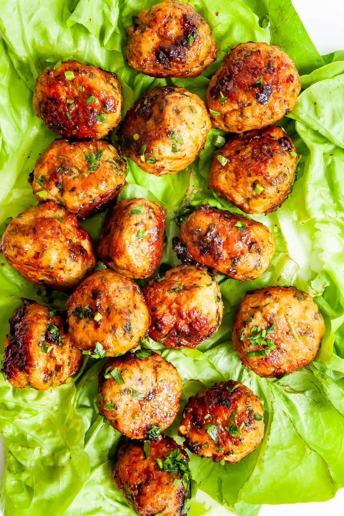 Firecracker Chicken Meatballs over lettuce leaves