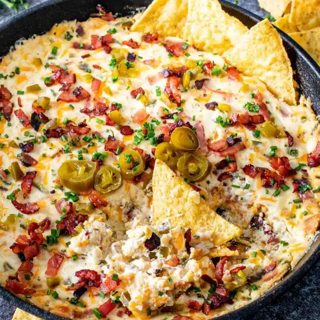 jalapeno popper dip in a black cast iron skillet fresh out of the oven.